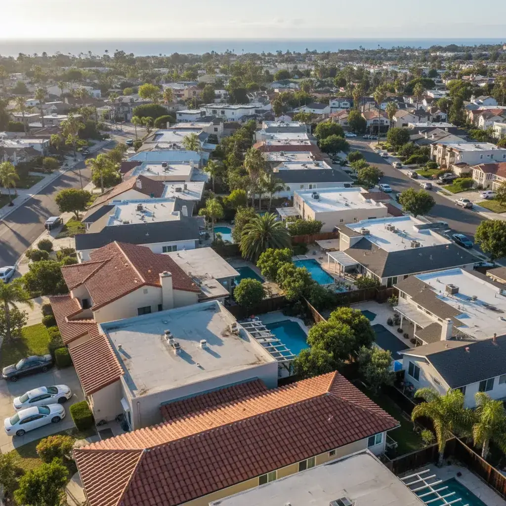 Aerial view of a San Diego neighborhood showing a mix of red Spanish tile, asphalt shingle, and flat roofs on a sunny afternoon